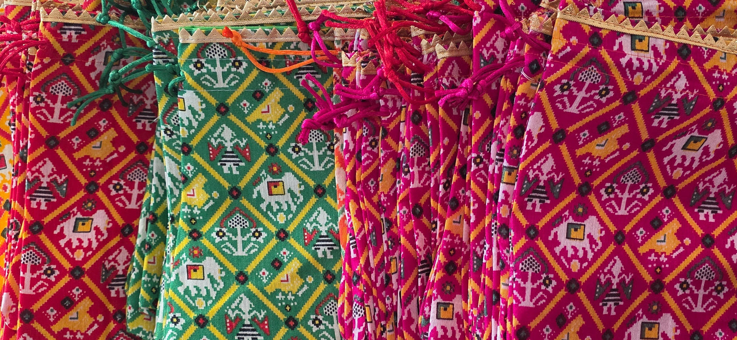 Colorful fabric bags with intricate patterns on a textured surface