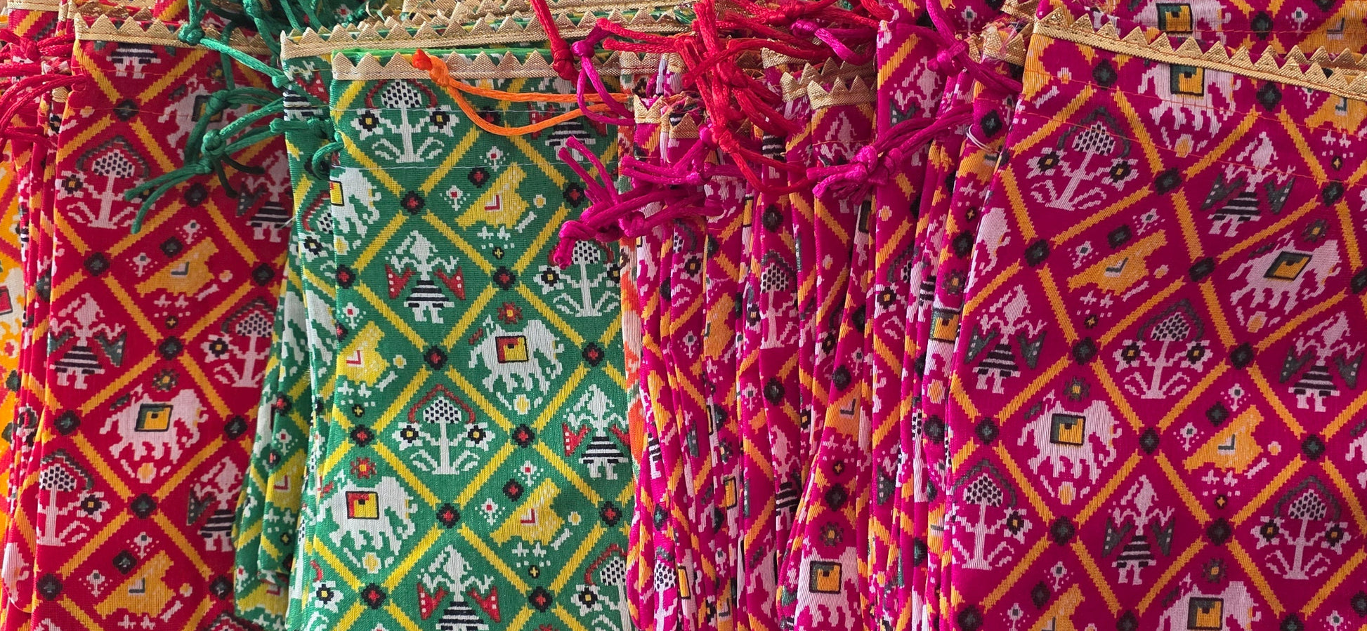 Colorful fabric bags with intricate patterns on a textured surface