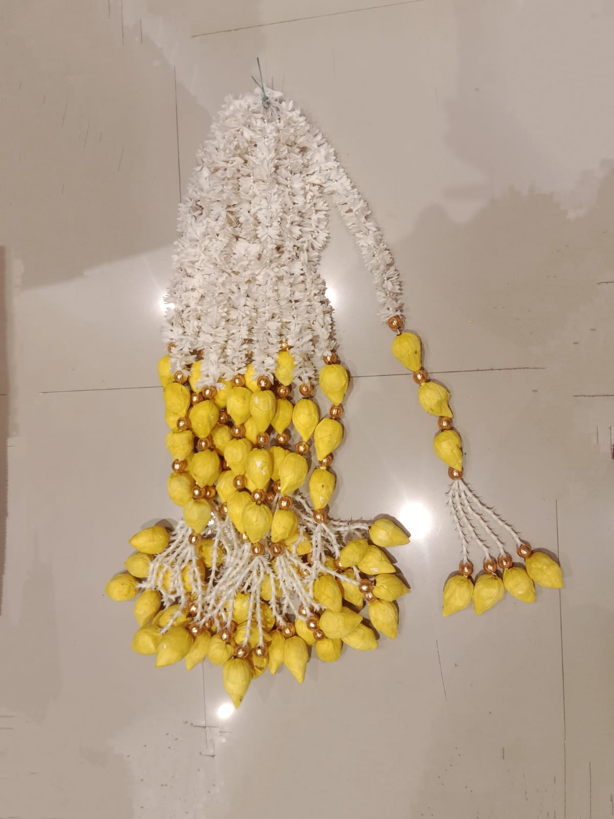 White gajra hanging with golden bead+yellow lotus lily tessel